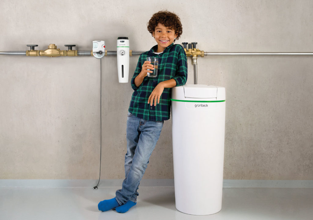 Wasseraufbereitungsgerät mit Kind und Glas Wasser